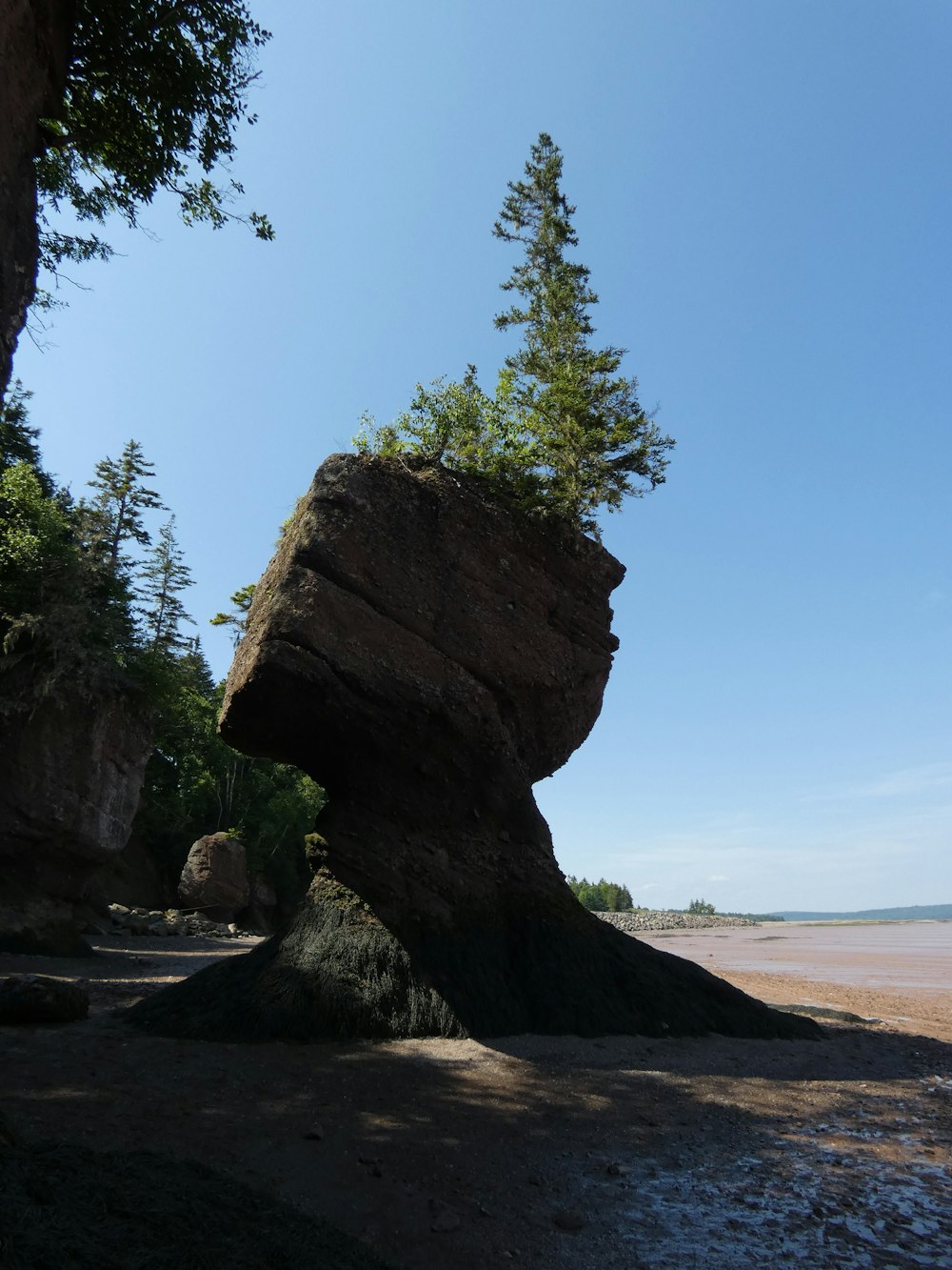 a large rock sitting on top of a sandy beach