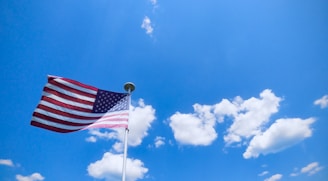 An American flag waving proudly against a clear blue sky