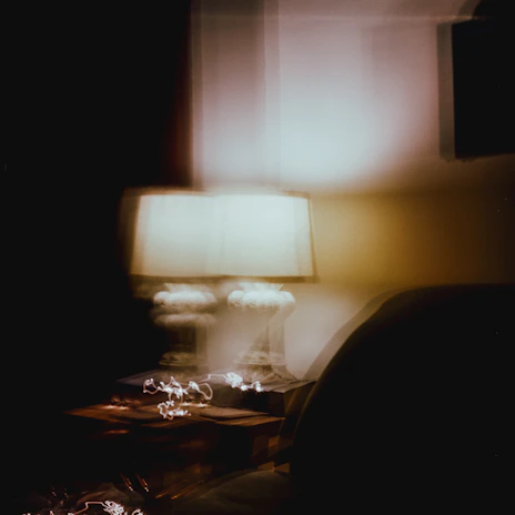 Lifestyle shot capturing the calming glow of smart comfort devices in a modern, minimalist living room with dark tones and subtle blur effects.