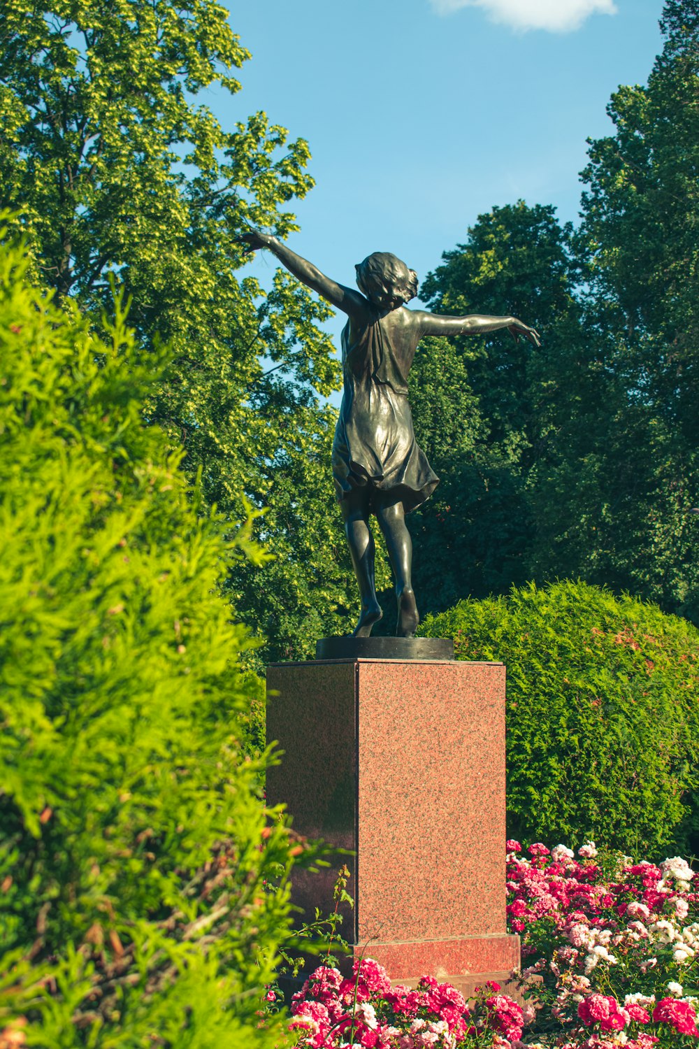 a statue of a girl holding her arms out