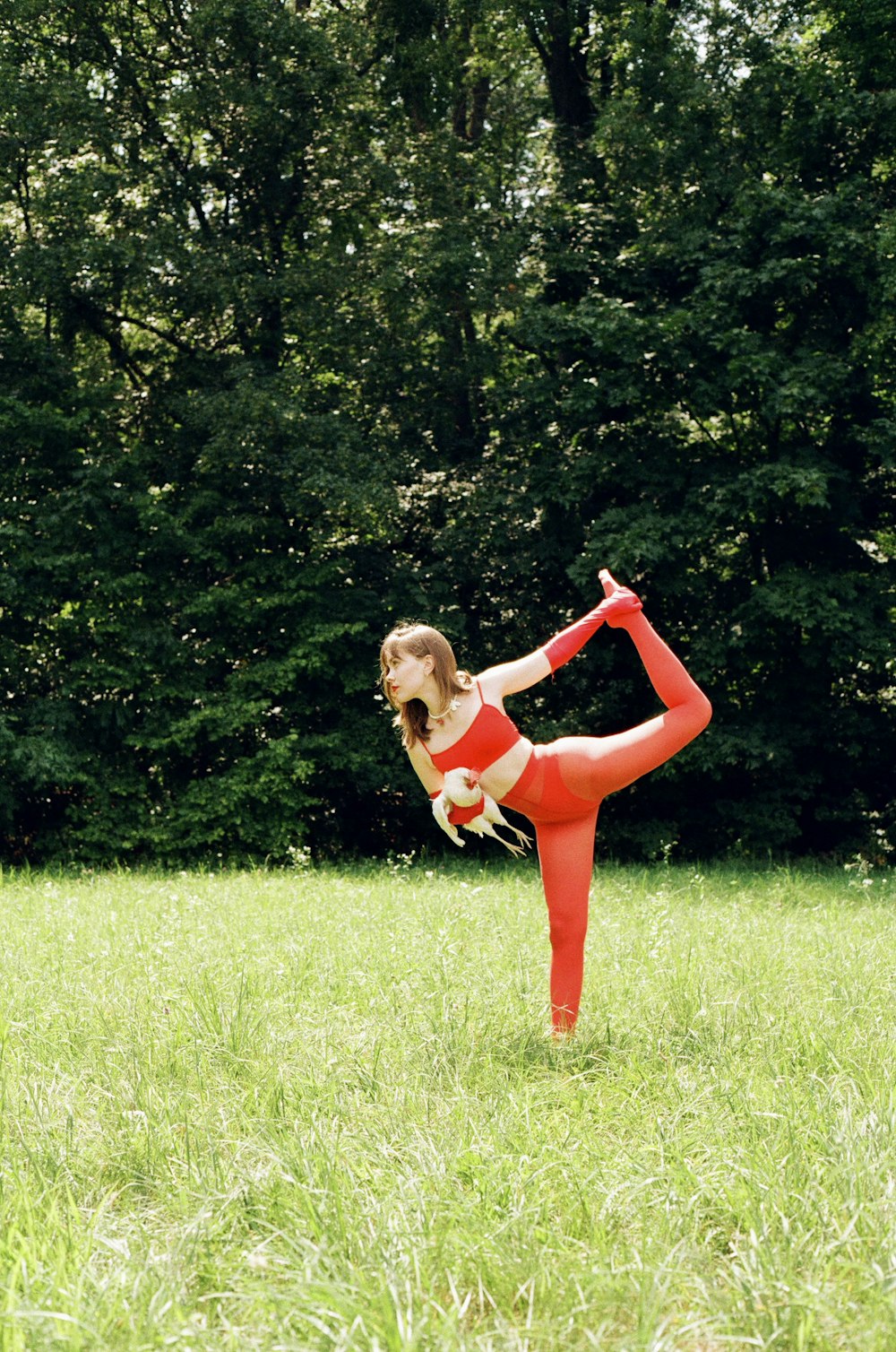 a woman in red and white is doing a yoga pose