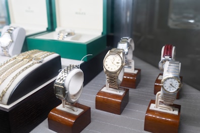 A collection of luxury watches displayed on velvet cushions showcasing variety.