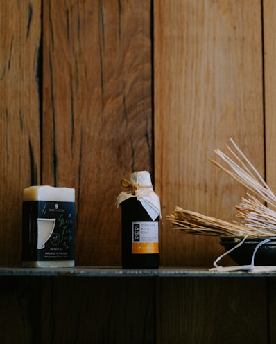 A rustic wooden shelf displaying natural men's grooming products with green plants around, evoking a fresh and earthy vibe.
