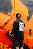 a man is painting a wall with graffiti