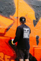 a man is painting a wall with graffiti