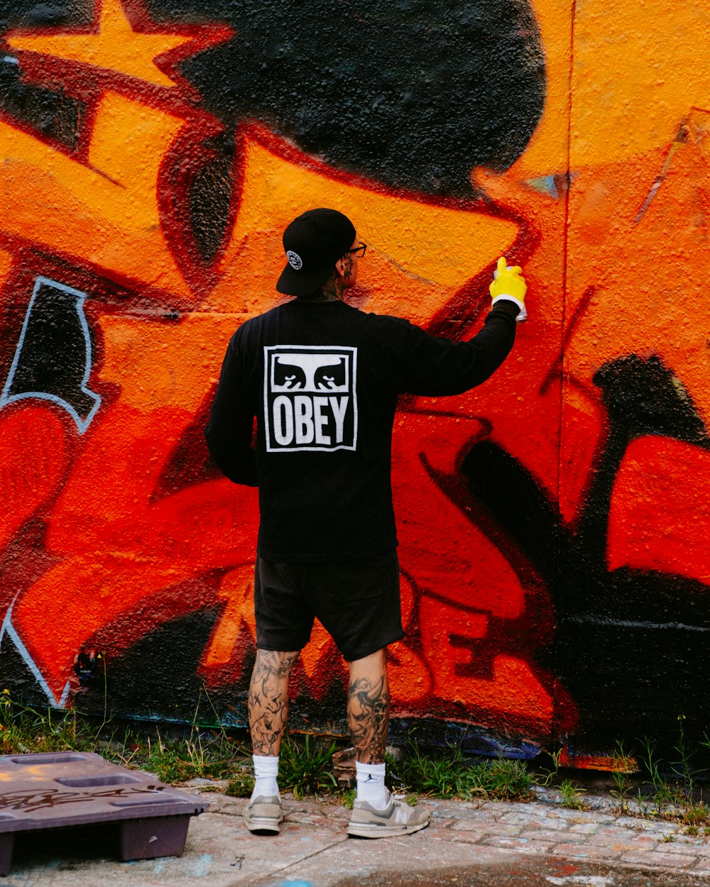 a man painting a wall with graffiti on it