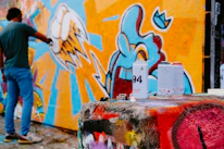 A painter applying vibrant paint on a wall, showcasing detailed mural work.