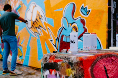 A painter applying vibrant paint on a wall, showcasing detailed mural work.