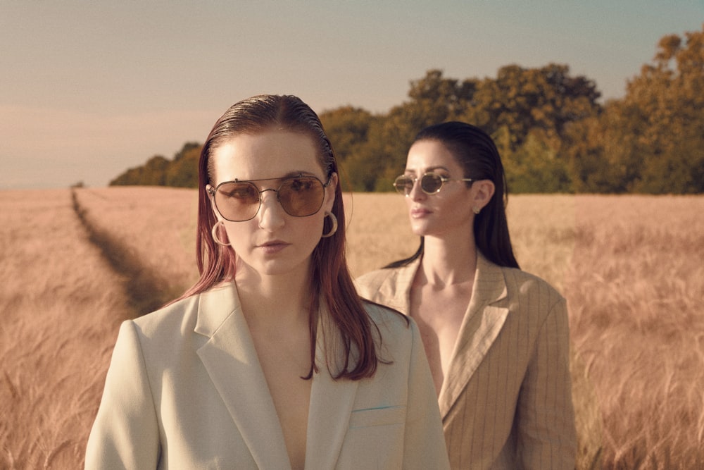 two women standing in a field of tall grass