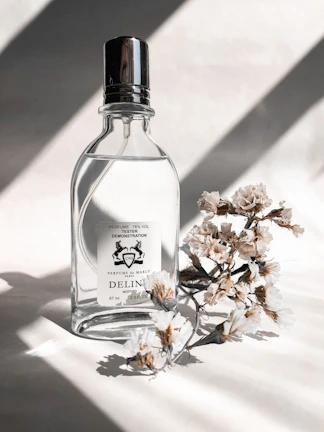 Artistic shot of a perfume bottle with delicate golden light reflections highlighting its minimalist design.