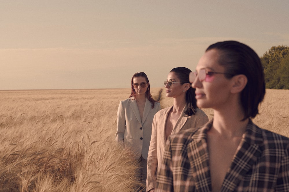 a group of women standing in a wheat field