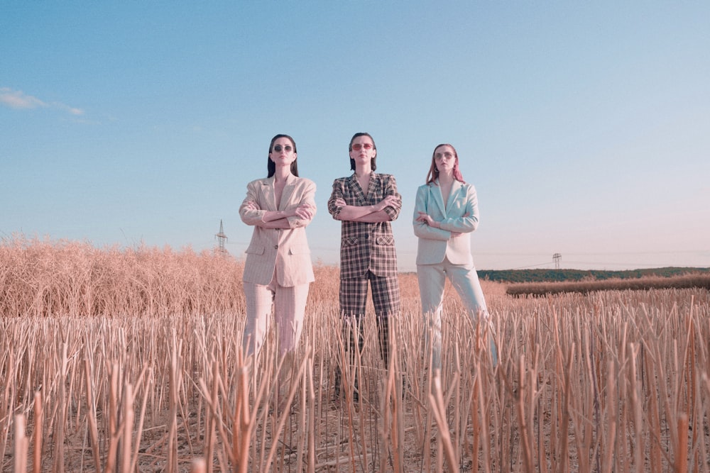 a group of three women standing in a field