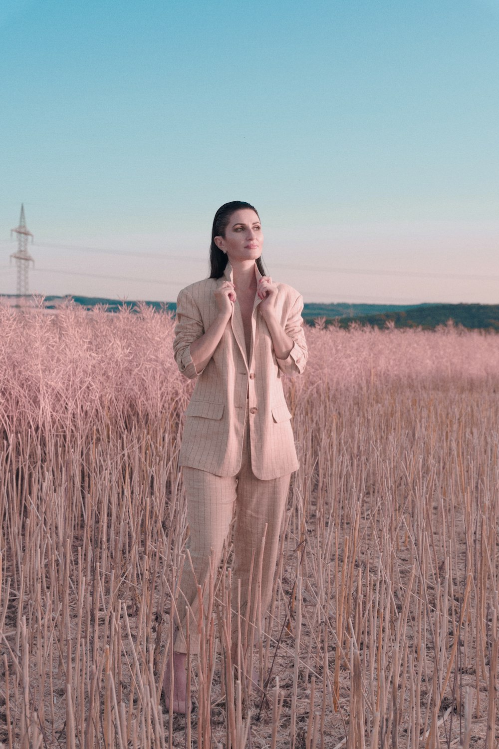 a woman in a suit standing in a field