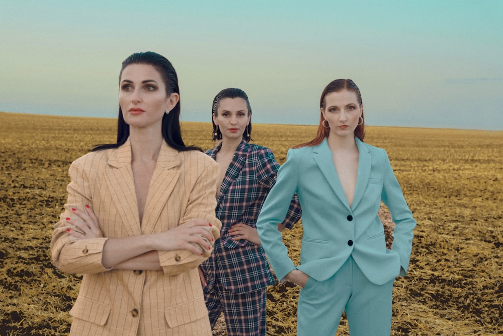 a group of women standing next to each other in a field