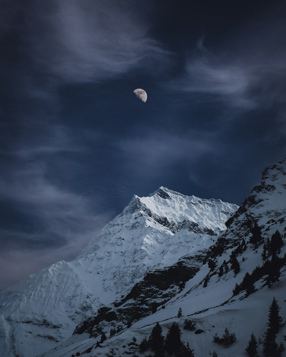 Une montagne couverte de neige sous un ciel nuageux