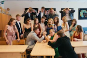 a group of people standing and sitting around a table
