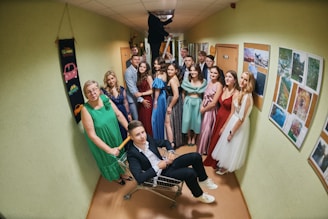 a group of people standing and sitting in a hallway