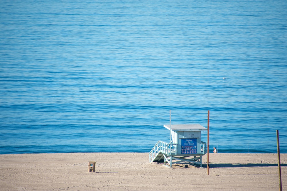 a lifeguard chair on the beach next to the ocean
