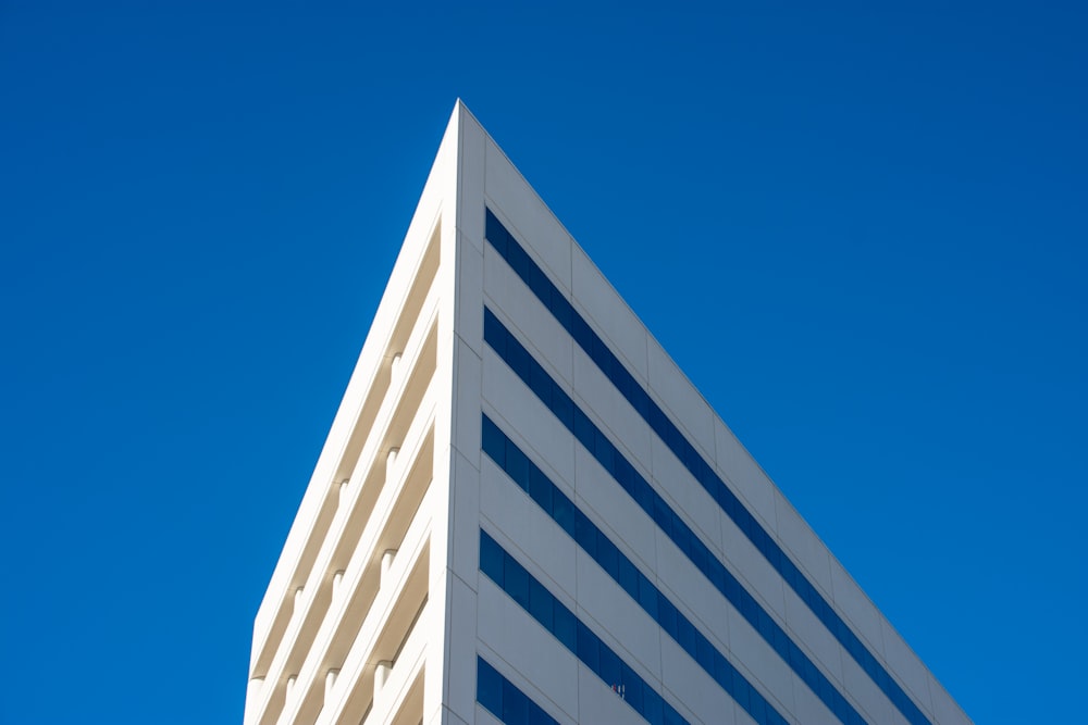 a tall white building with a blue sky in the background