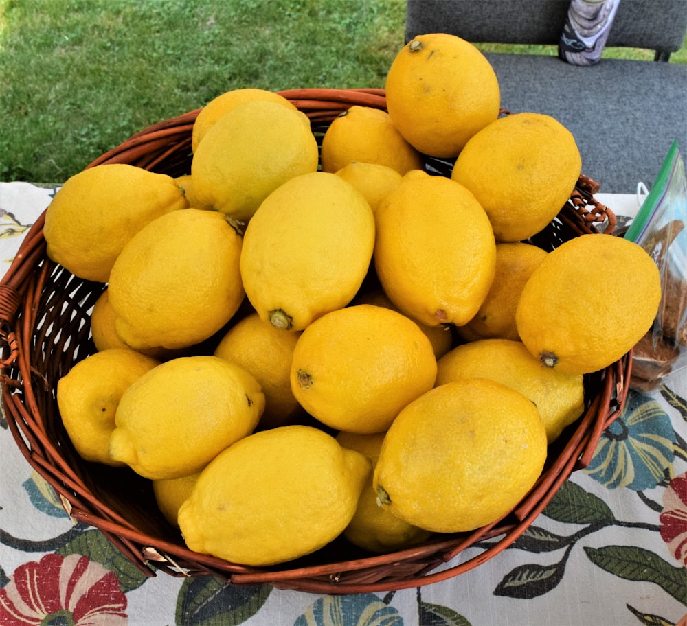 a basket full of lemons sitting on a table