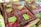 Several clear plastic containers filled with fresh red raspberries are stacked in cardboard boxes. Labels on the containers indicate the brand as Driscoll's and mention that the raspberries are organic.