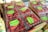 Several clear plastic containers filled with fresh red raspberries are stacked in cardboard boxes. Labels on the containers indicate the brand as Driscoll's and mention that the raspberries are organic.