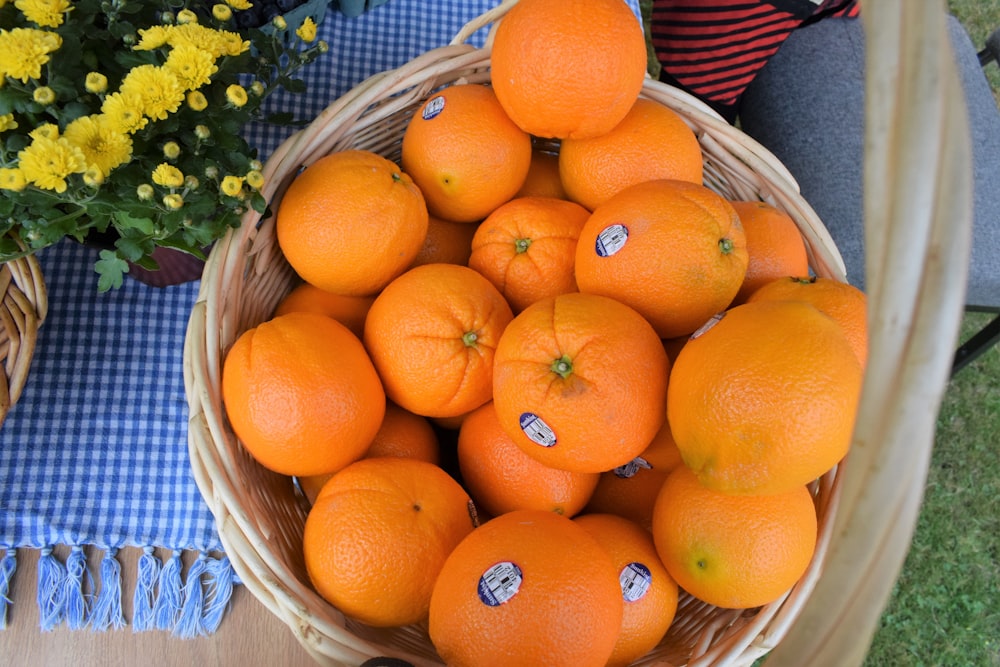 a basket full of oranges sitting on a table