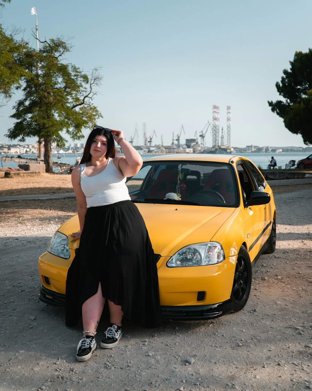 a woman standing next to a yellow car