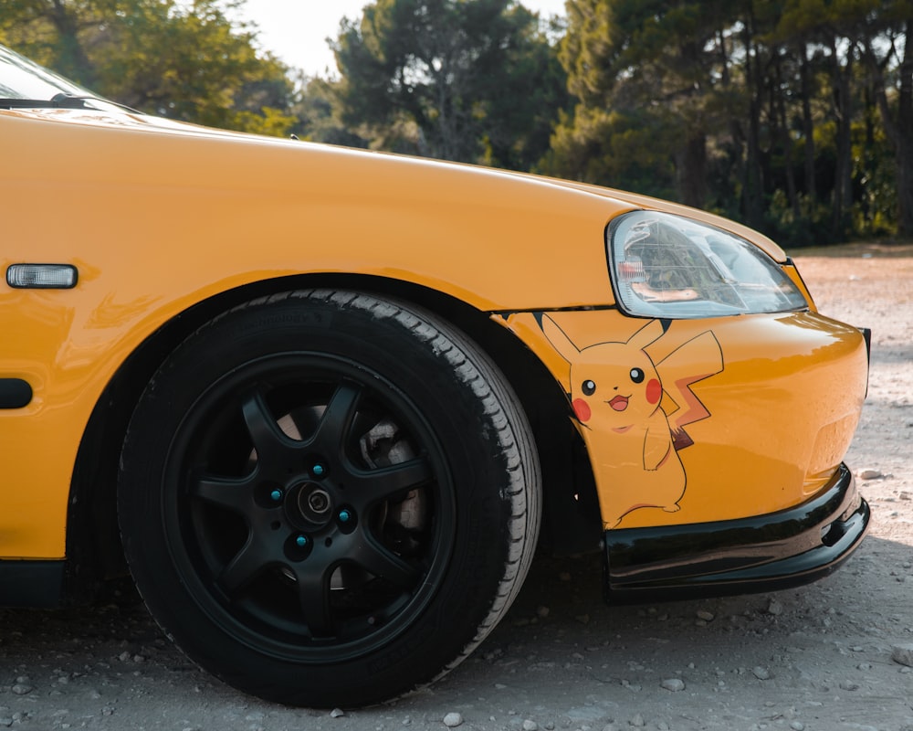 a yellow car with a pikachu painted on the side