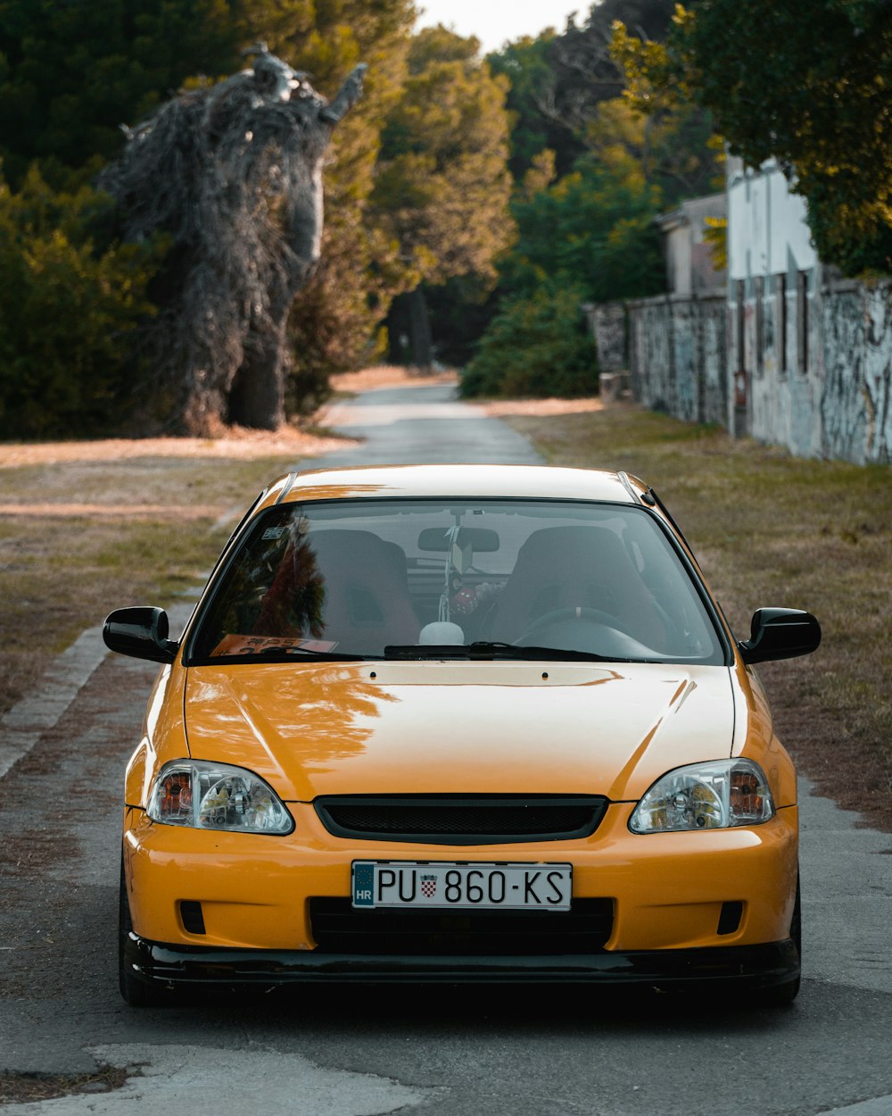 a yellow car parked on the side of a road