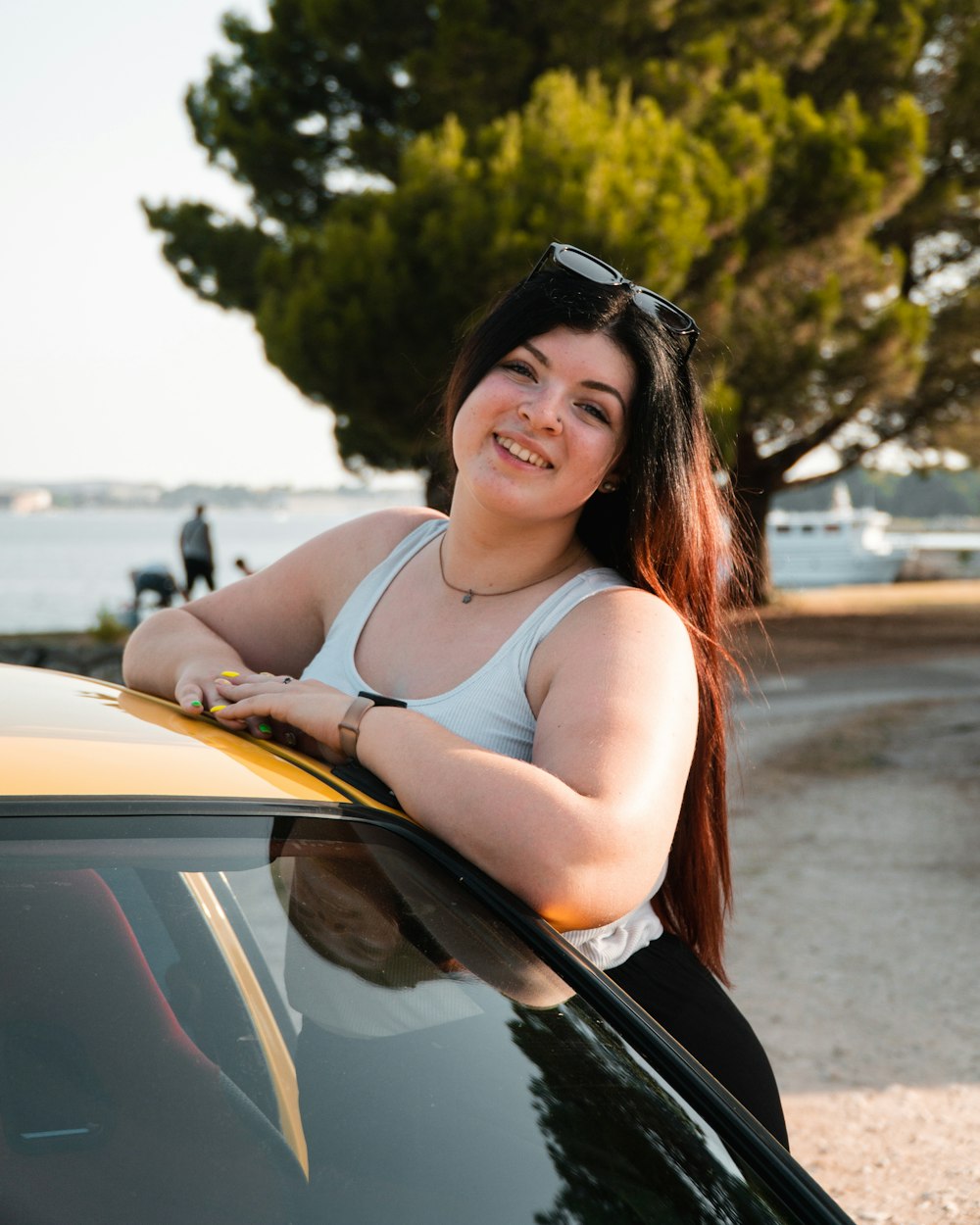 a woman leaning on the hood of a car