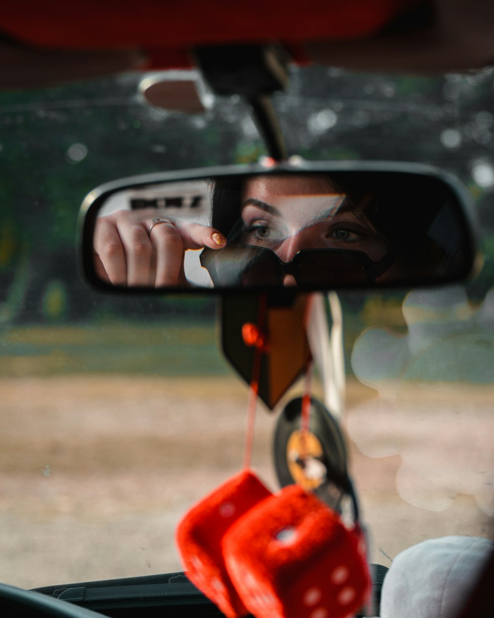 Il riflesso di una donna nello specchietto retrovisore laterale di un'auto