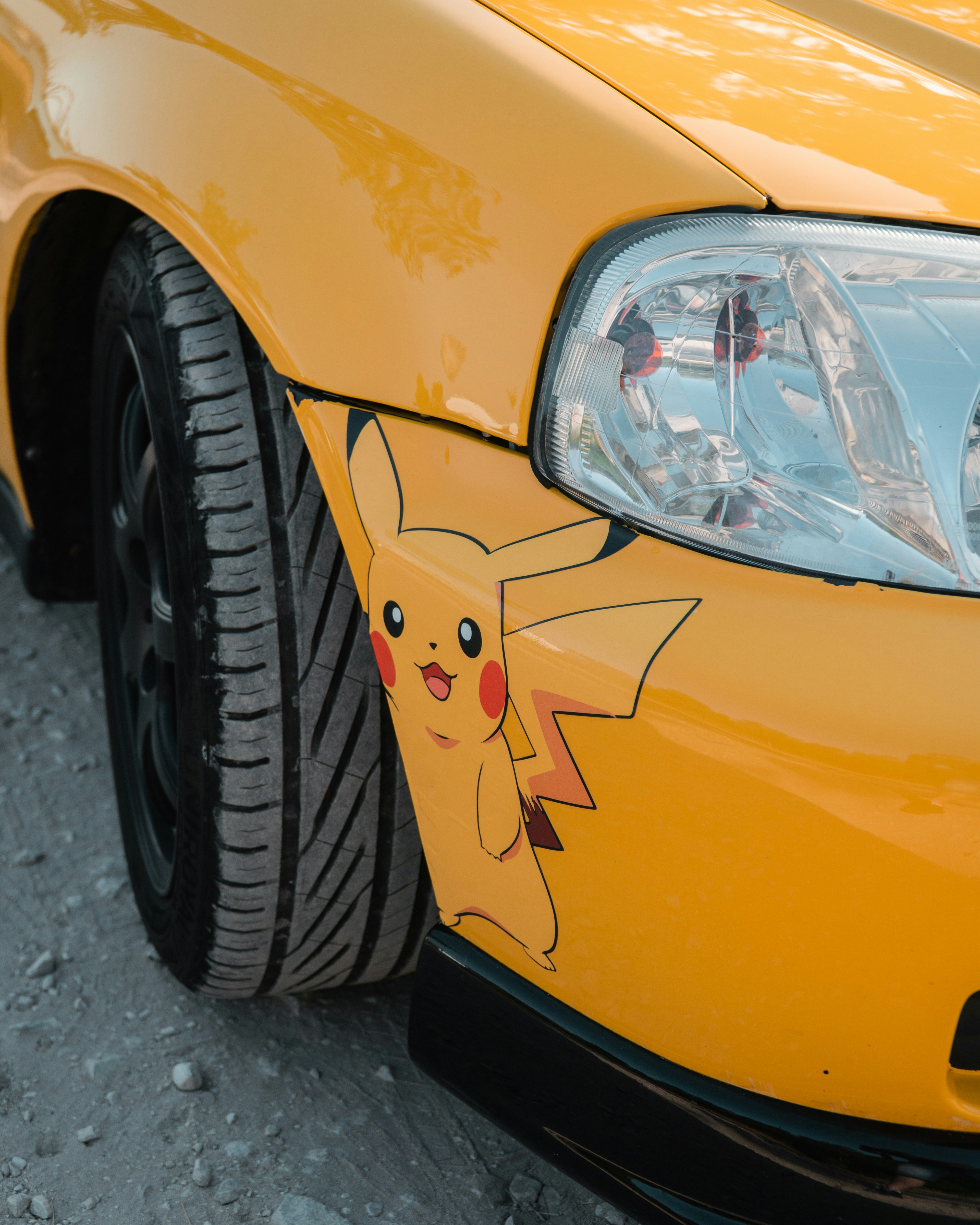 A close up of a yellow car with a pikachu sticker on it photo – Free ...