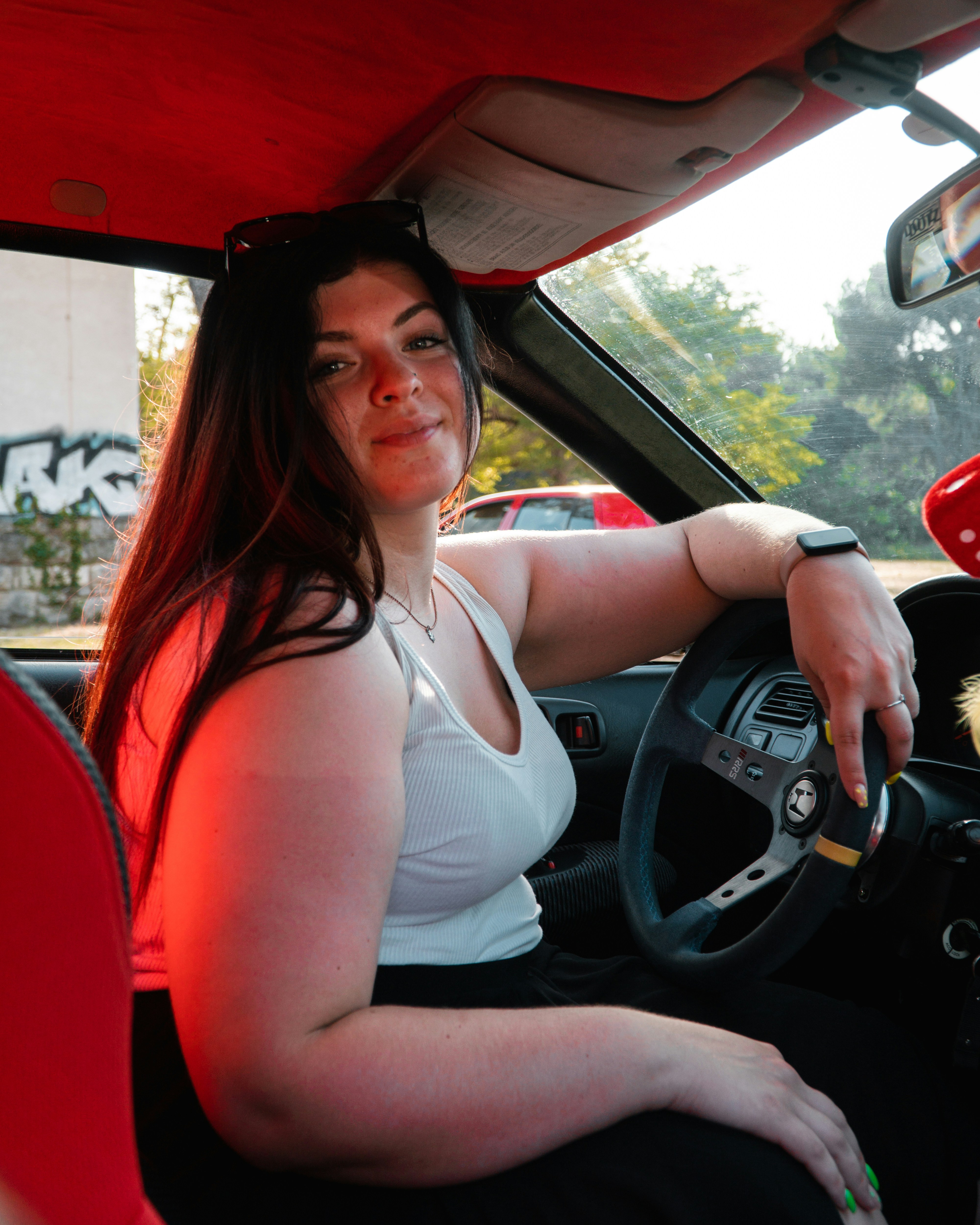 a woman sitting in a car with a dog in her lap