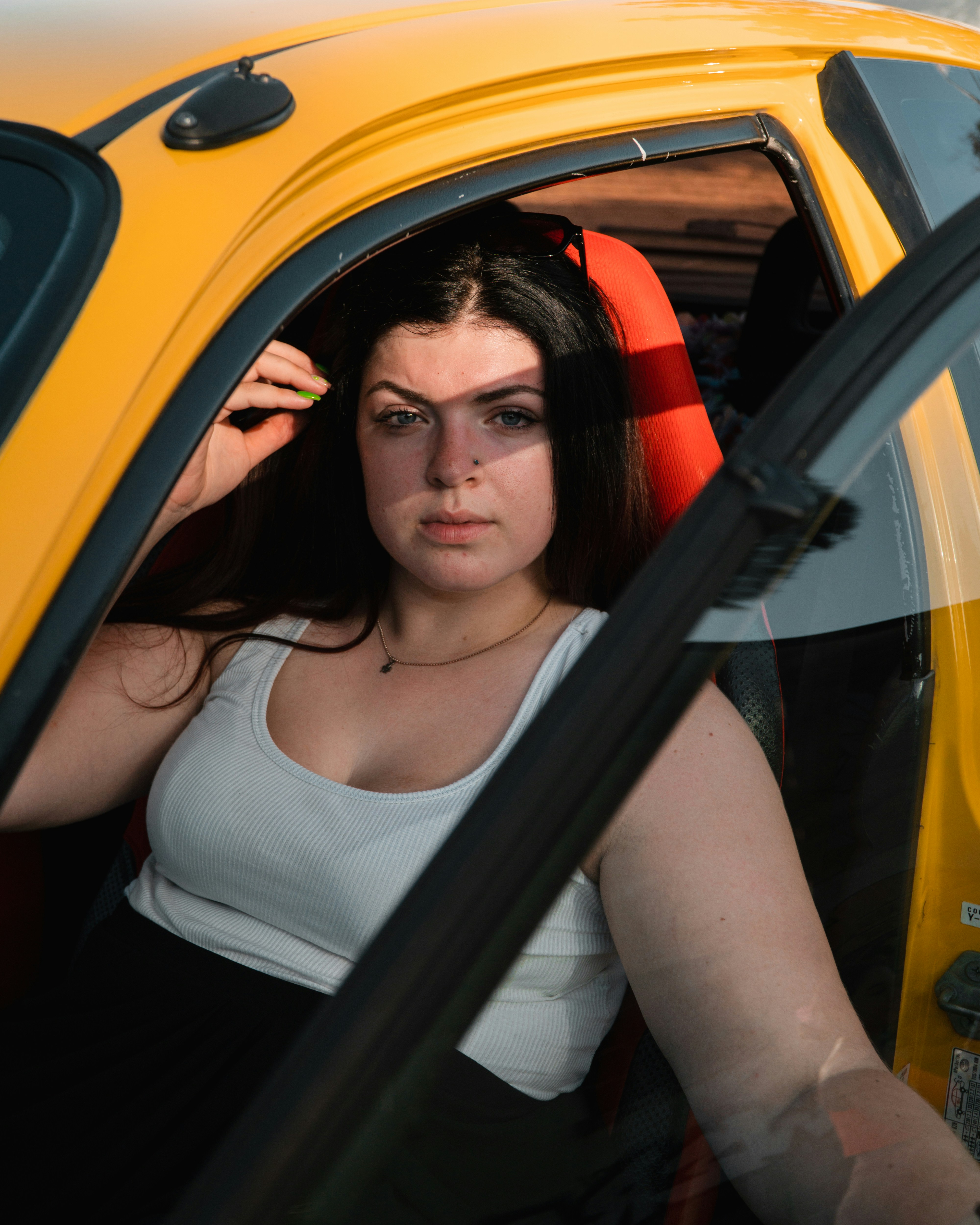 a woman sitting in a yellow car looking out the window