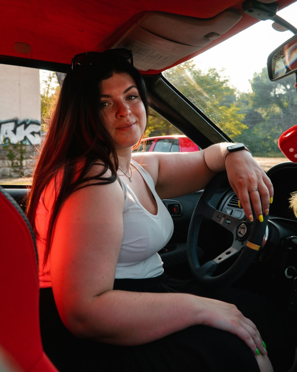 a woman sitting in a car with a stuffed animal