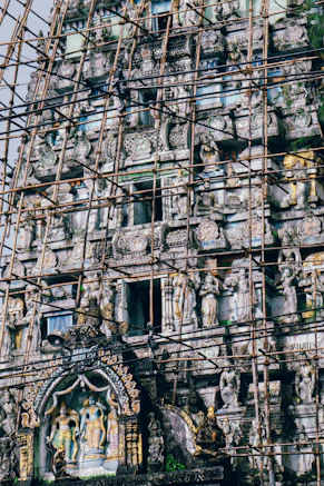 scaffolding surrounding a building with statues on it