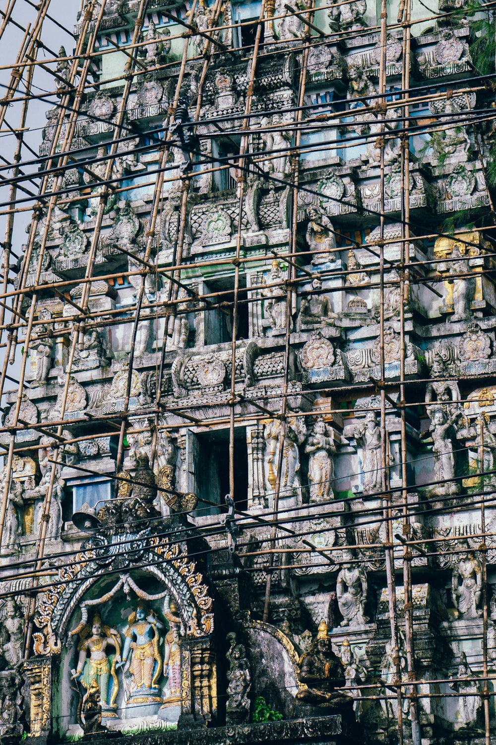scaffolding surrounding a building with statues on it