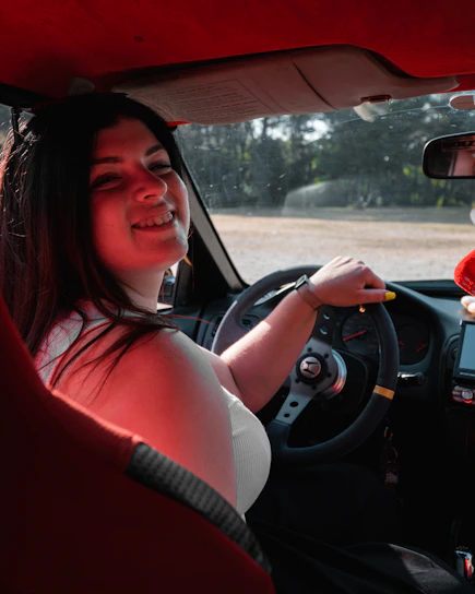 A cheerful driver handing over keys to a happy passenger outside a cozy home at night.