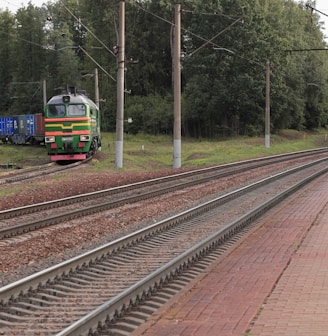 a train traveling down train tracks next to a forest