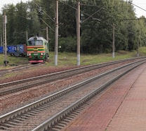 a train traveling down train tracks next to a forest