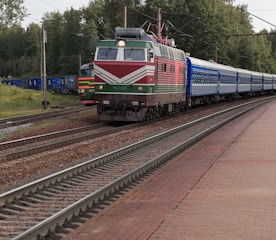 a train traveling down train tracks next to a forest