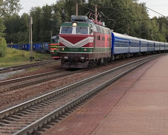 a train traveling down train tracks next to a forest