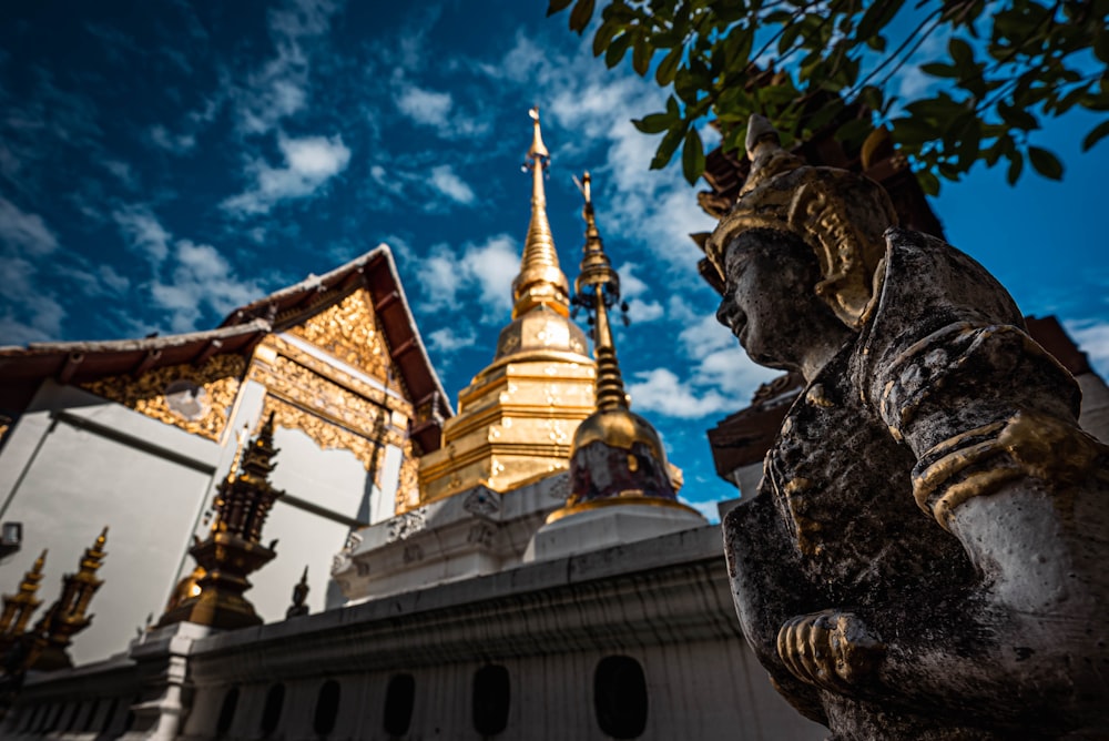 a statue in front of a golden building