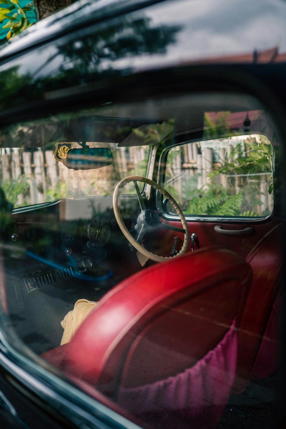 a red car with a steering wheel in a driveway