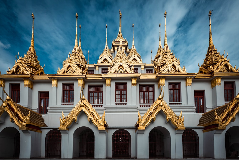 a white and gold building with a blue sky in the background