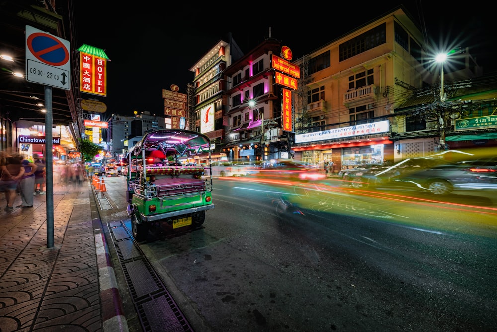 a city street at night with cars and people