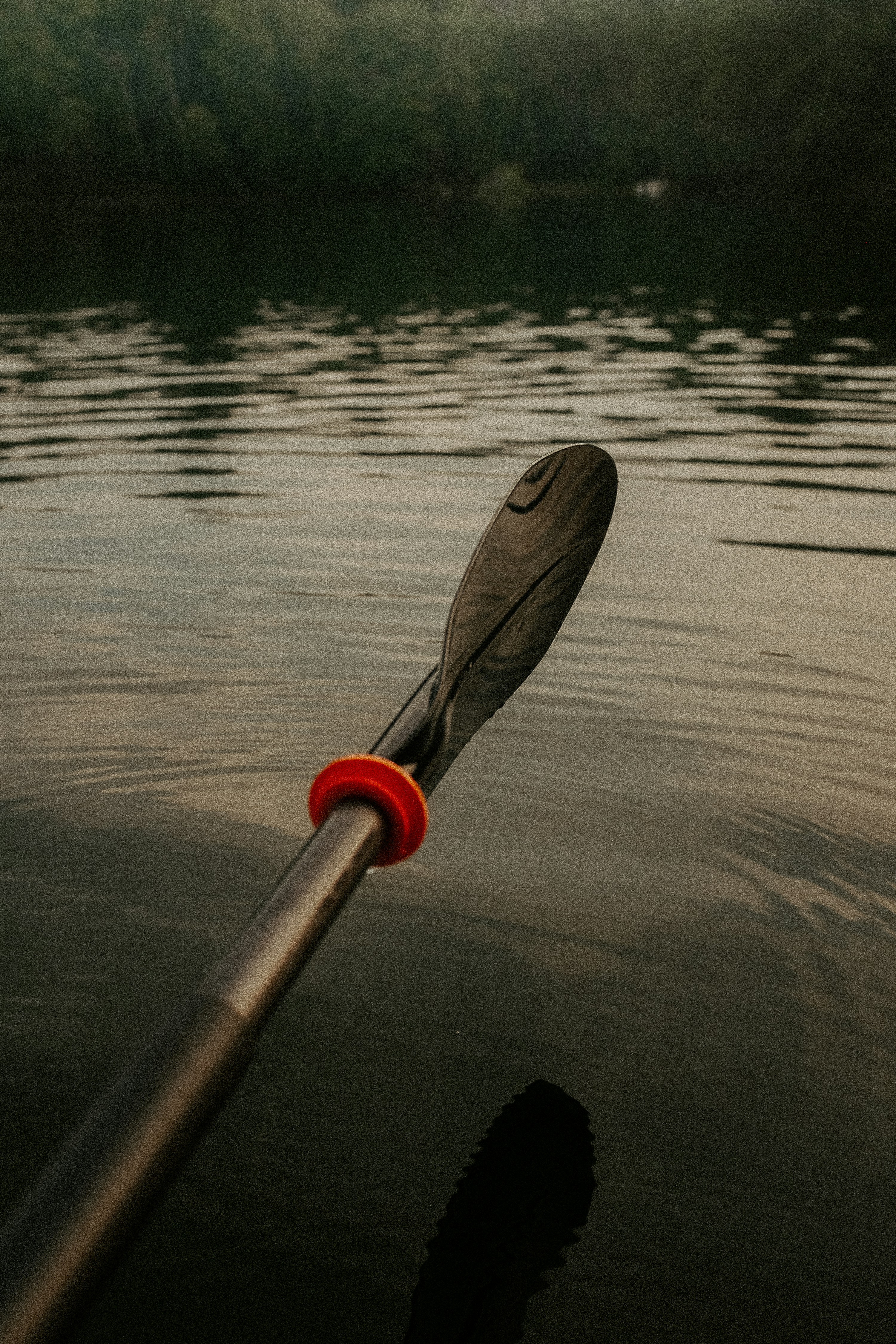 a red and black paddle on a body of water
