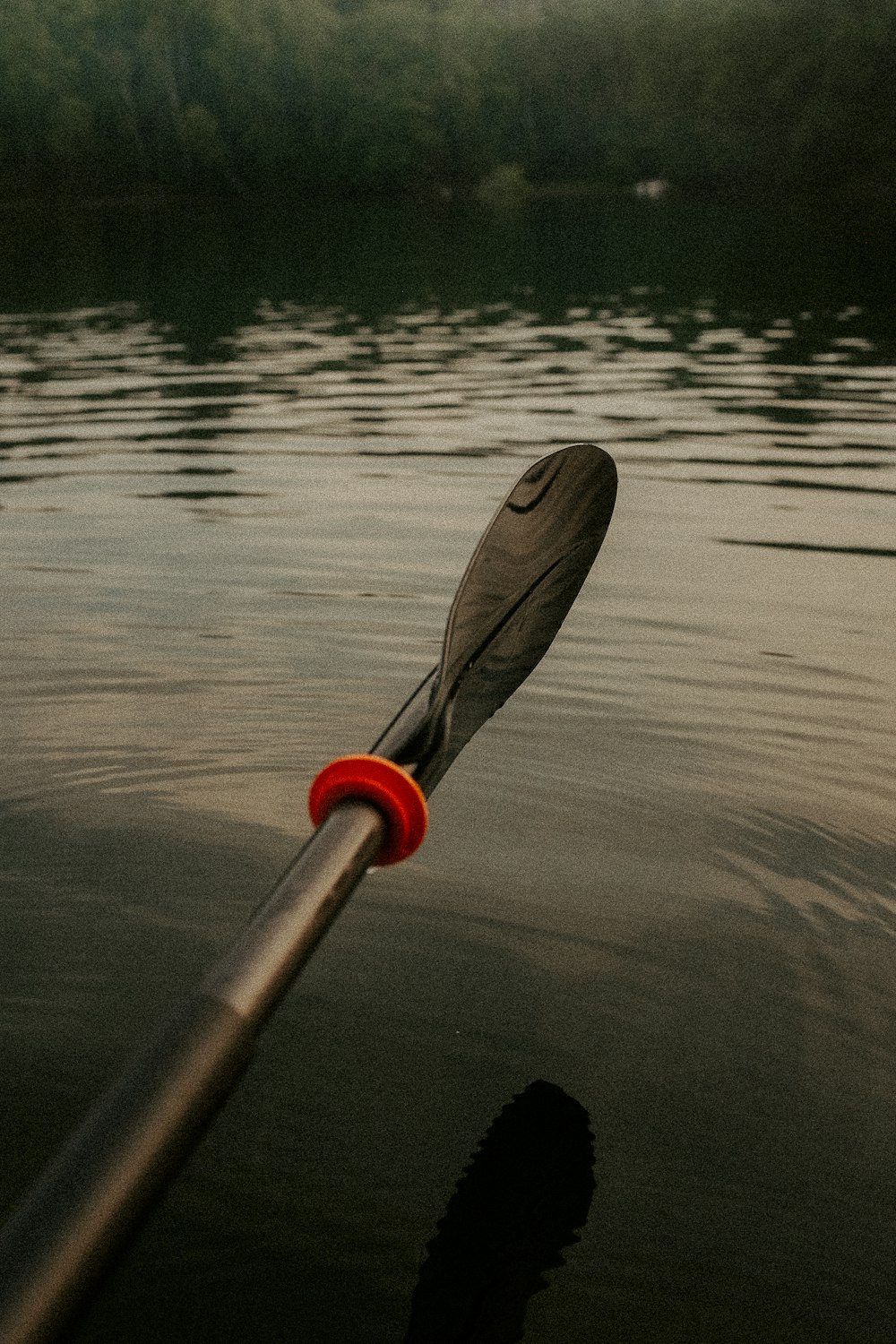 a red and black paddle on a body of water