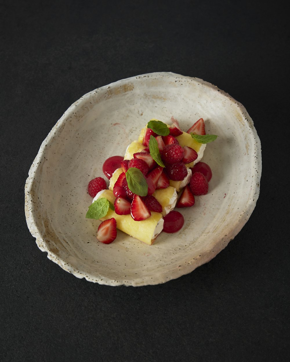 a white bowl filled with fruit on top of a table